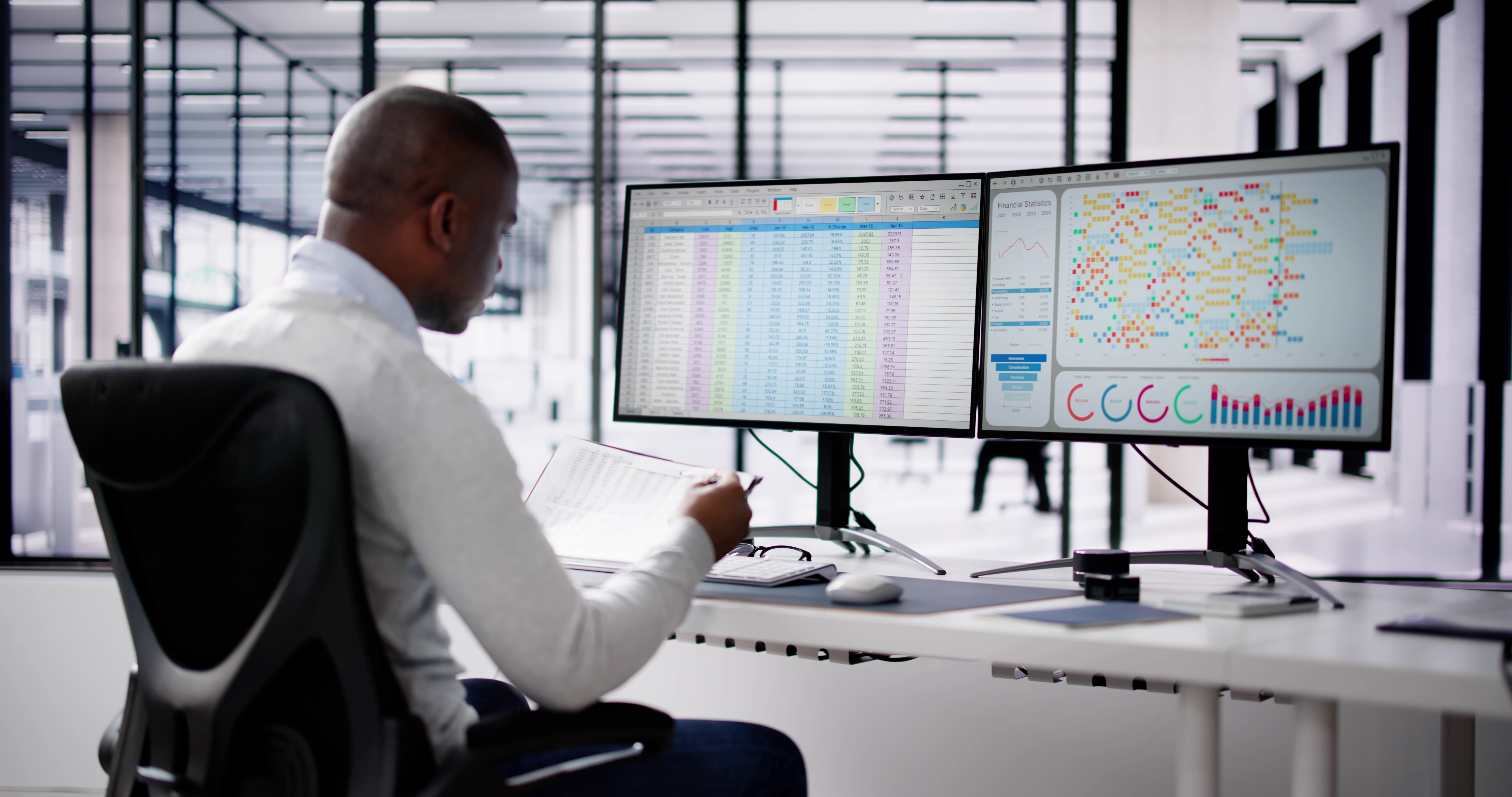 Analyst reviewing data across two monitors